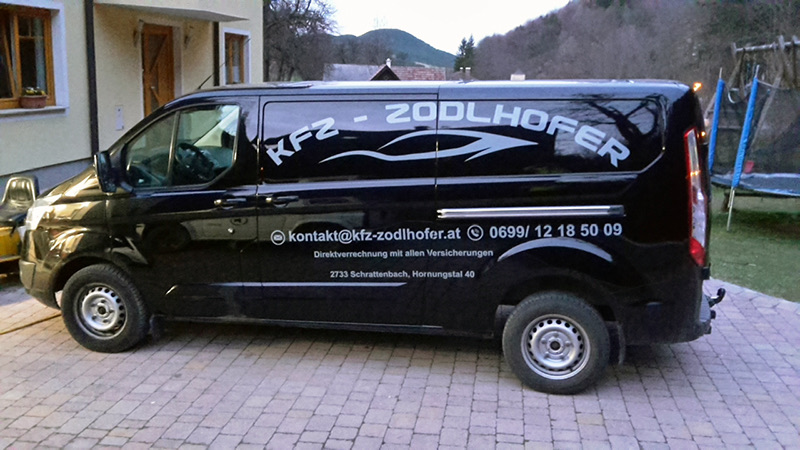 Ford Transit Custom mit weißer Folienbeschriftung und Kontaktdaten